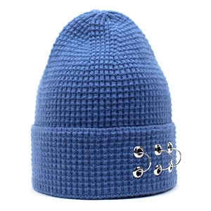 Détail d'un bonnet bleu en maille gaufre avec trois anneaux métalliques argentés décoratifs