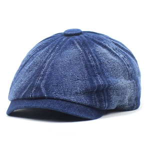 Detailed view of heavy washed blue denim fabric on a classic octagonal newsboy cap