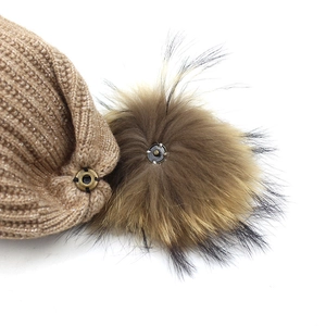 Knitted beanie hat with detachable brown faux fur pom pom and snap button