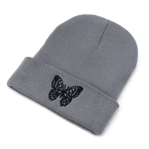 Medium gray knitted beanie for women featuring a detailed black butterfly embroidery