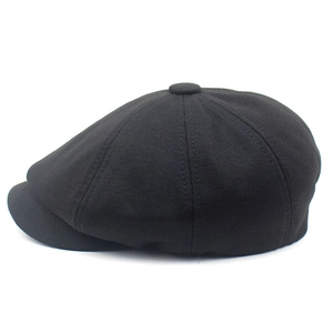 Detailed view of black cotton newsboy cap featuring an eight-panel crown and textured fabric