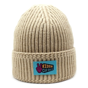 Close-up of khaki ribbed knit beanie with blue embroidered rider car race patch