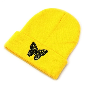 Close-up of black butterfly embroidery on bright yellow ribbed knit beanie hat for women