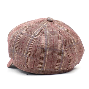 Detailed close-up of reddish-brown houndstooth pattern fabric on newsboy cap