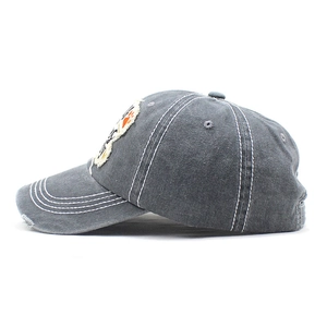 Detail of grey washed cotton baseball cap with orange paw embroidery and contrast stitching