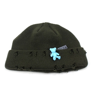 Dark green knitted beanie featuring distressed holes and a cute blue bear charm pendant
