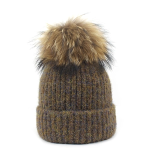 Détail du bonnet en maille marron chiné avec pompon duveteux et texture côtelée épaisse