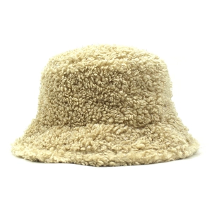 Detailed close-up of fluffy beige faux shearling texture on warm winter bucket hat