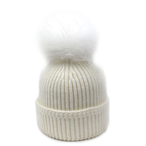 Primer plano de un gorro de punto acanalado blanco con pompón de pelo sintético