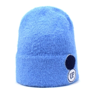 Detailopname van de hemelblauwe gebreide muts van imitatiebont met zachte pluche en UP-patch