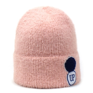 Detail van de roze gebreide muts van imitatienerts met zachte textuur en ronde UP-patch