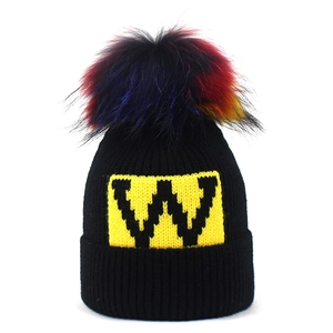 Berretto in maglia nera con pompon colorato in ecopelliccia e toppa con logo W giallo