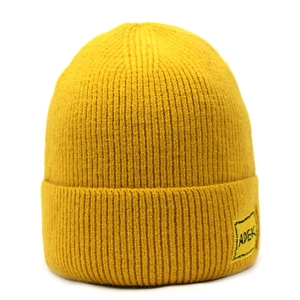 Dettaglio di un berretto in maglia giallo brillante con strisce e toppa logo ADEK