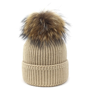 Cozy beige ribbed knit winter beanie with a large fluffy faux fur pompom for women