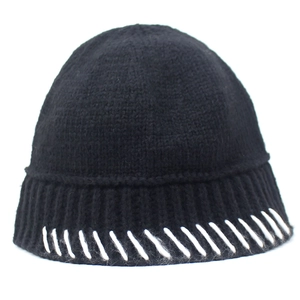 Detail of black knitted beanie with white contrast stitching on the rim and fine texture