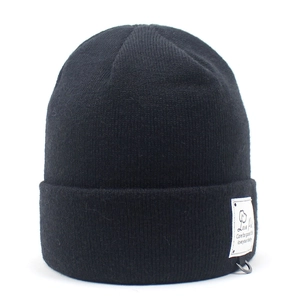 Close-up of black knit beanie with white Love Pet logo tag and metal D-ring detail