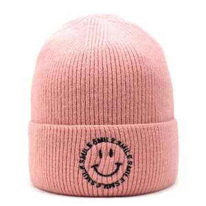Close-up of pink knit beanie showing ribbed texture and embroidered black smiley logo