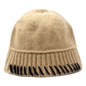 Detail of light brown knit bucket hat with black decorative whipstitch trim on edge