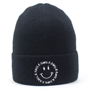 Close-up of white smile emoji and SMILE word embroidery on black knit beanie cuff
