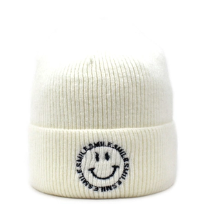 Close-up of smile embroidery on ivory knitted beanie with a soft ribbed texture
