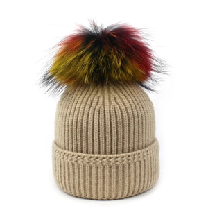 Detail of khaki knit beanie featuring a large colorful faux fur pom-pom on top