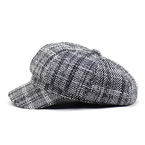 Detail of vintage black and white plaid newsboy cap with thick woven wool texture