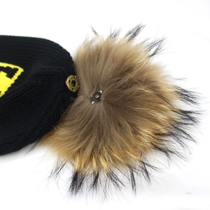 Black knit beanie featuring a brown faux fur pom-pom and yellow jacquard letter logo