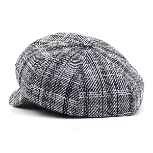 Detail shot of the vintage plaid pattern and textured wool fabric on a newsboy cap