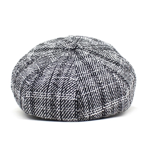 Close-up of vintage grey herringbone tweed texture on a retro newsboy cap