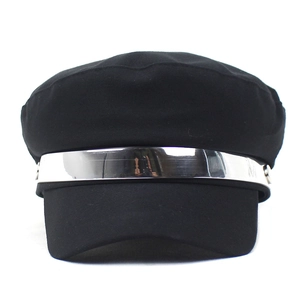 Détail d'une casquette gavroche noire avec bande métallique argentée et ornement M