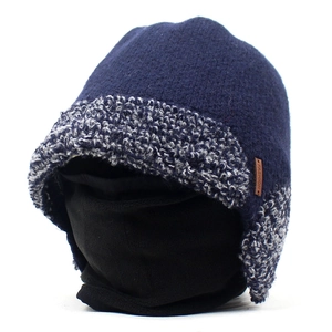 Detailed close-up of blue knit hat with soft fleece lining and brown leather fashion tag