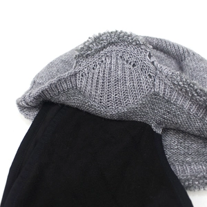 Detail of winter knitted hat showing grey ribbed texture and thick black fleece lining