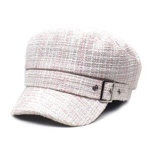 Détail du chapeau de marin en tweed rose et beige avec boucle métallique et œillets argentés