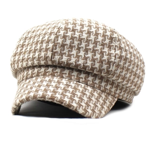 Detailed close-up of brown houndstooth newsboy cap showing thick tweed fabric texture