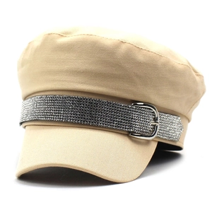 Detail of khaki newsboy cap featuring sparkling rhinestone band and silver buckle
