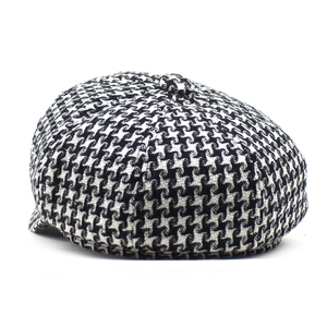 Detailed view of the classic black and white houndstooth wool fabric on a baker boy cap