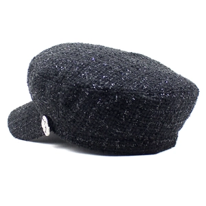 Détail de la casquette gavroche en tweed noir avec fils métalliques argentés et bouton latéral