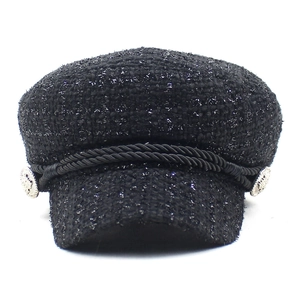 Vue détaillée de la casquette gavroche en tweed noir avec fils argentés et tresse décorative