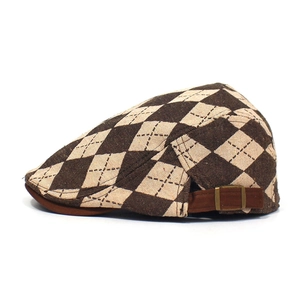 Detailed side view of brown and beige argyle flat cap with adjustable bronze buckle