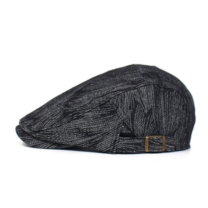 Detail of dark gray denim beret featuring a vintage bronze metal adjustment buckle