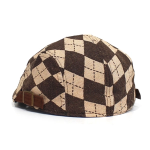 Close-up of brown argyle beret hat with adjustable side buckle and wool texture