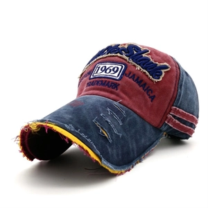 Dettaglio cappello baseball vintage con ricamo 1969 e bordo della visiera sfrangiato