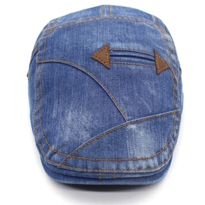 Close-up of washed denim flat cap with yellow stitching and brown leather patches