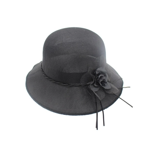 Détail d'un chapeau de soleil noir élégant à large bord avec une fleur décorative tissée