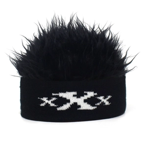 Detail of funny knit beanie featuring black shaggy faux fur hair and white XXX pattern