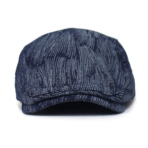 Detail of dark blue denim textured cotton beret showing fabric weave and short brim