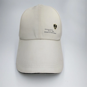 Detail view of reinforced stitching on brim of beige canvas sports baseball cap