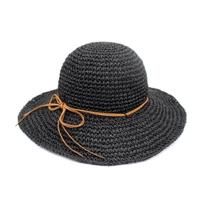 Close-up of black raffia sun hat with elegant brown leather cord bow decoration