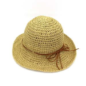 Detailed texture of hand-woven natural raffia straw hat with dark brown bow decoration