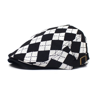 Detail of checkered flat cap showing contrast stitching and metal side buckle